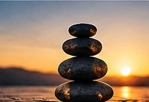 Balanced stacked stones at sunset